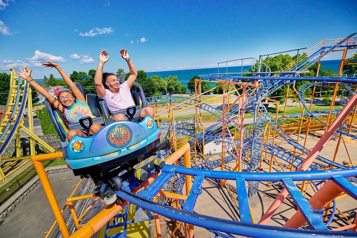 two people are riding a roller coaster at an amusement park .
