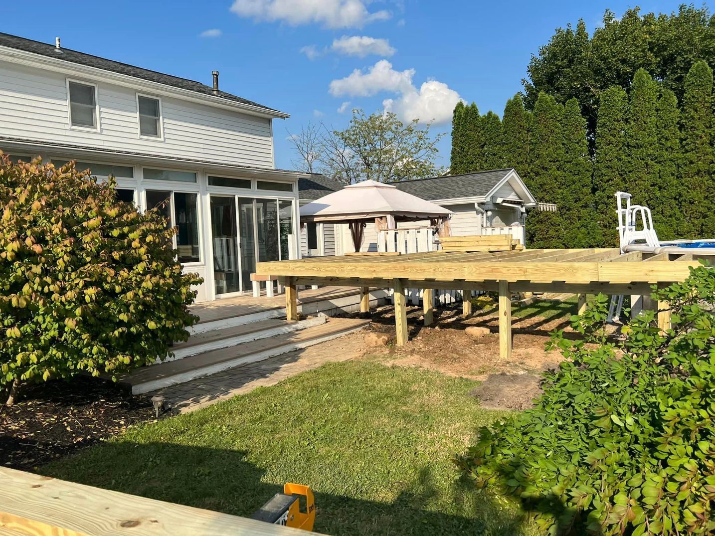 a wooden deck is being built in the backyard of a house