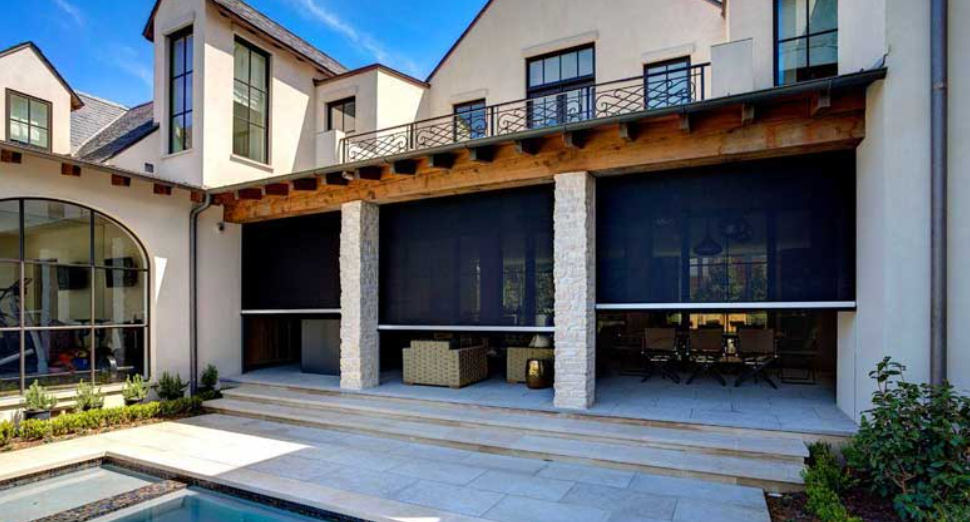Patio with retractable black screens, seating areas, and a pool.
