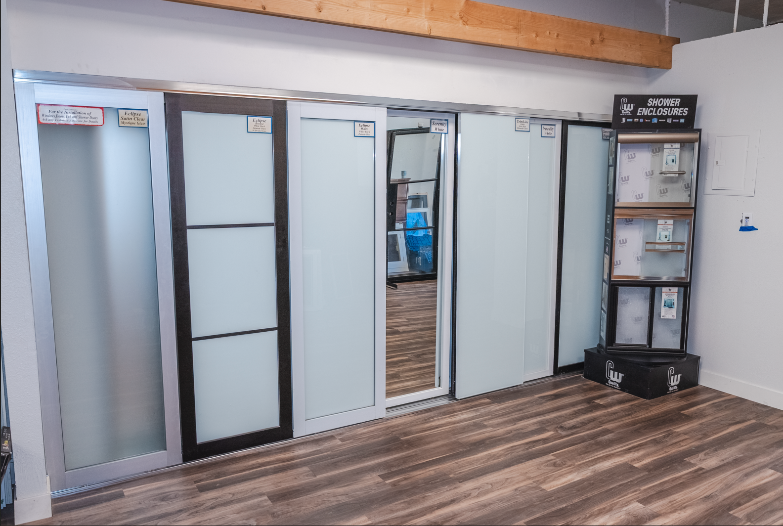 Display of sliding doors in showroom, various styles, and frame colors.