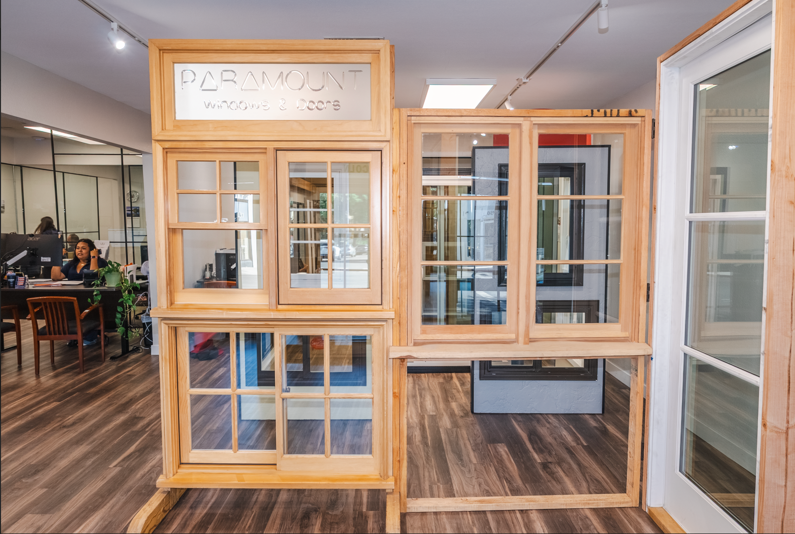 Display of wooden framed windows in a showroom setting; multiple window styles.