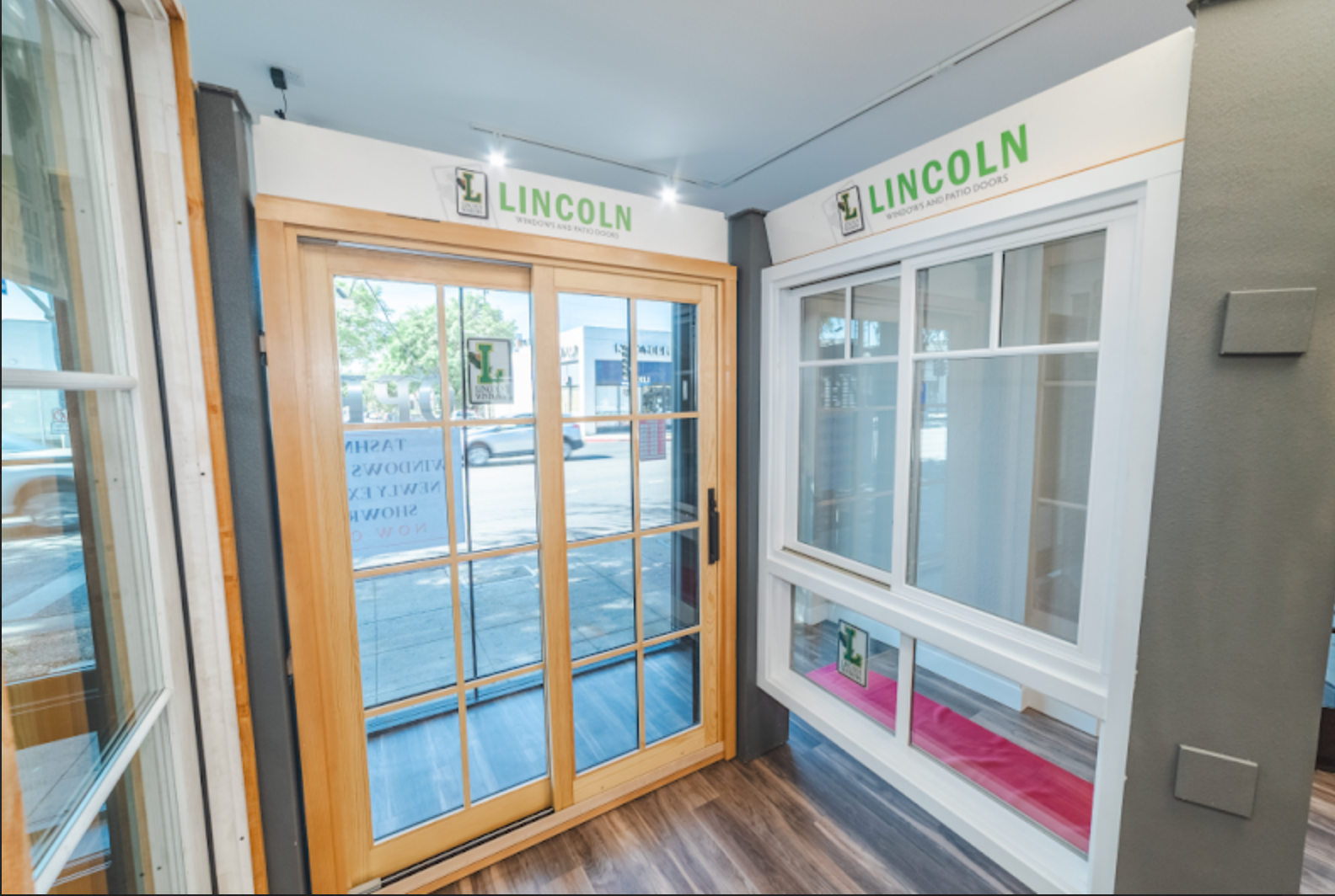 Sliding glass door and window display with a Lincoln logo, showcasing natural wood and white frames.
