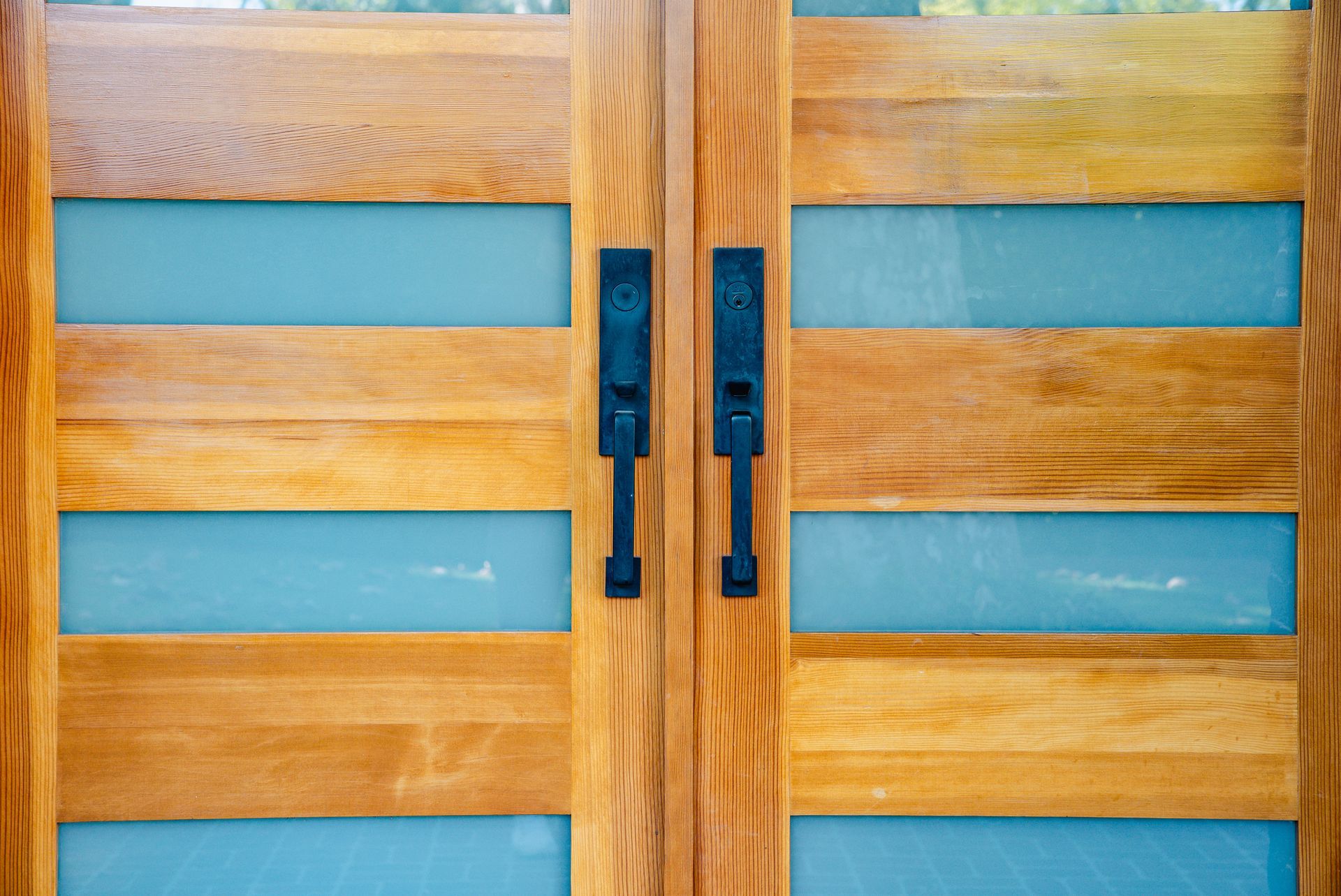 Wooden front door with blue glass inserts.