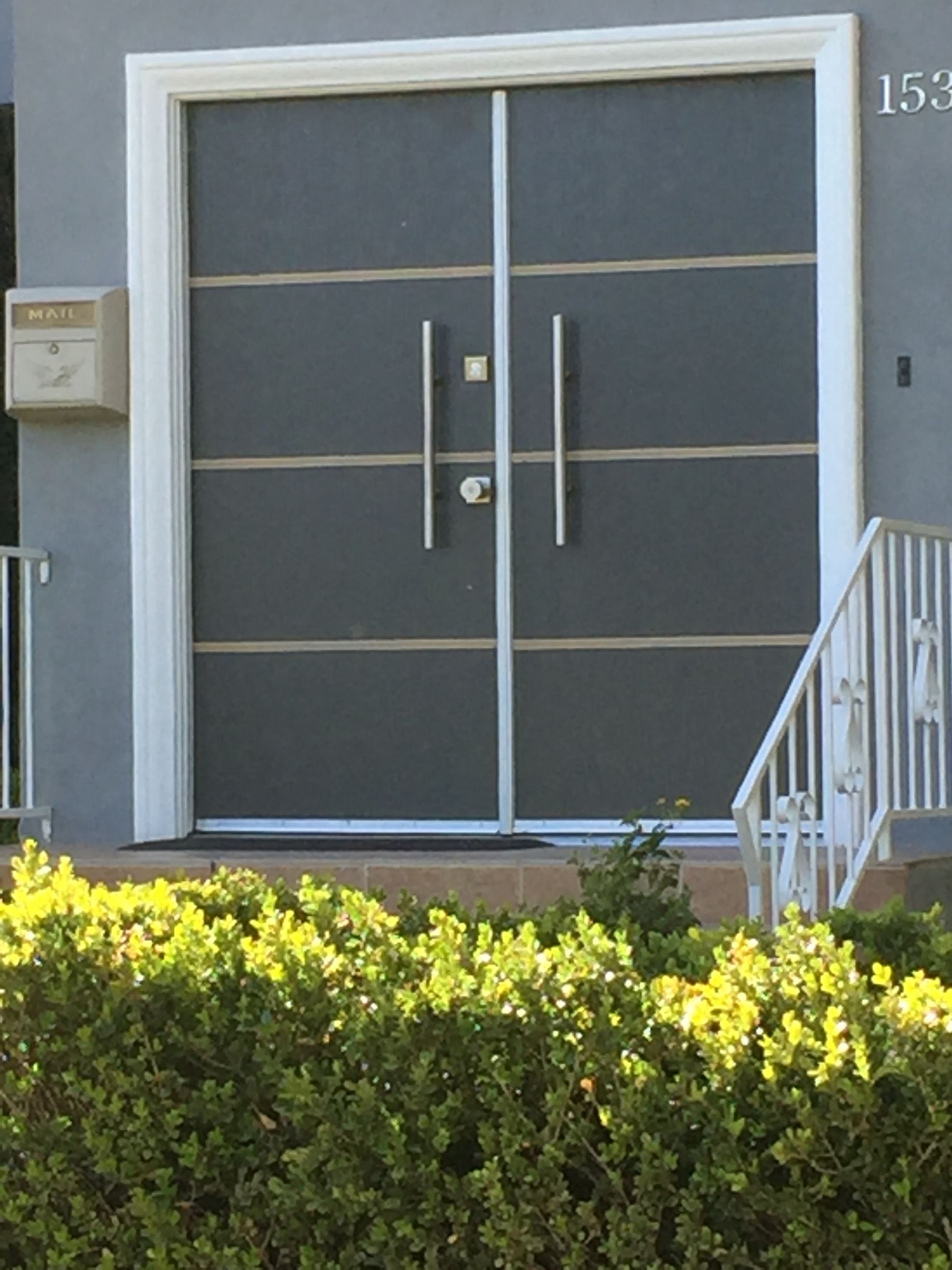 Gray double front doors with horizontal lines, white trim, and silver handles.