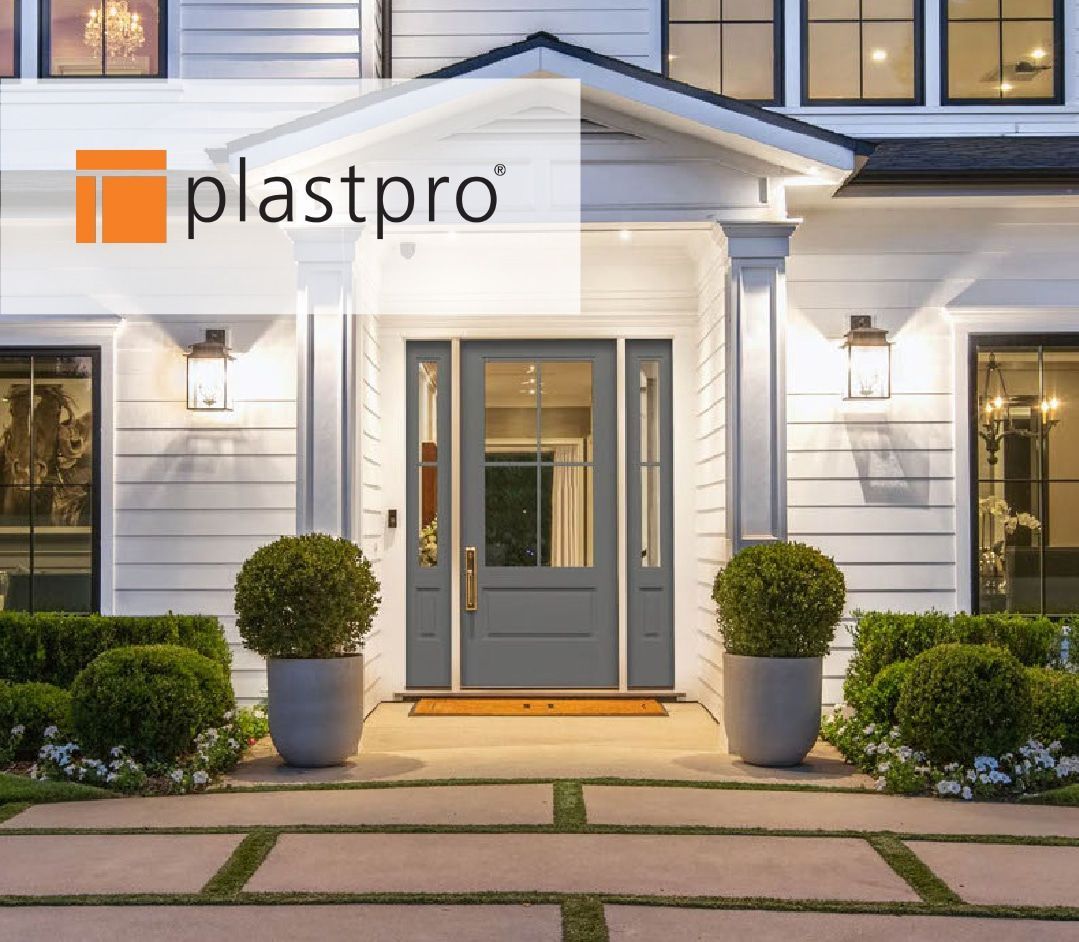 Front door of a house with a gray door, flanking planters, and Plastpro logo.