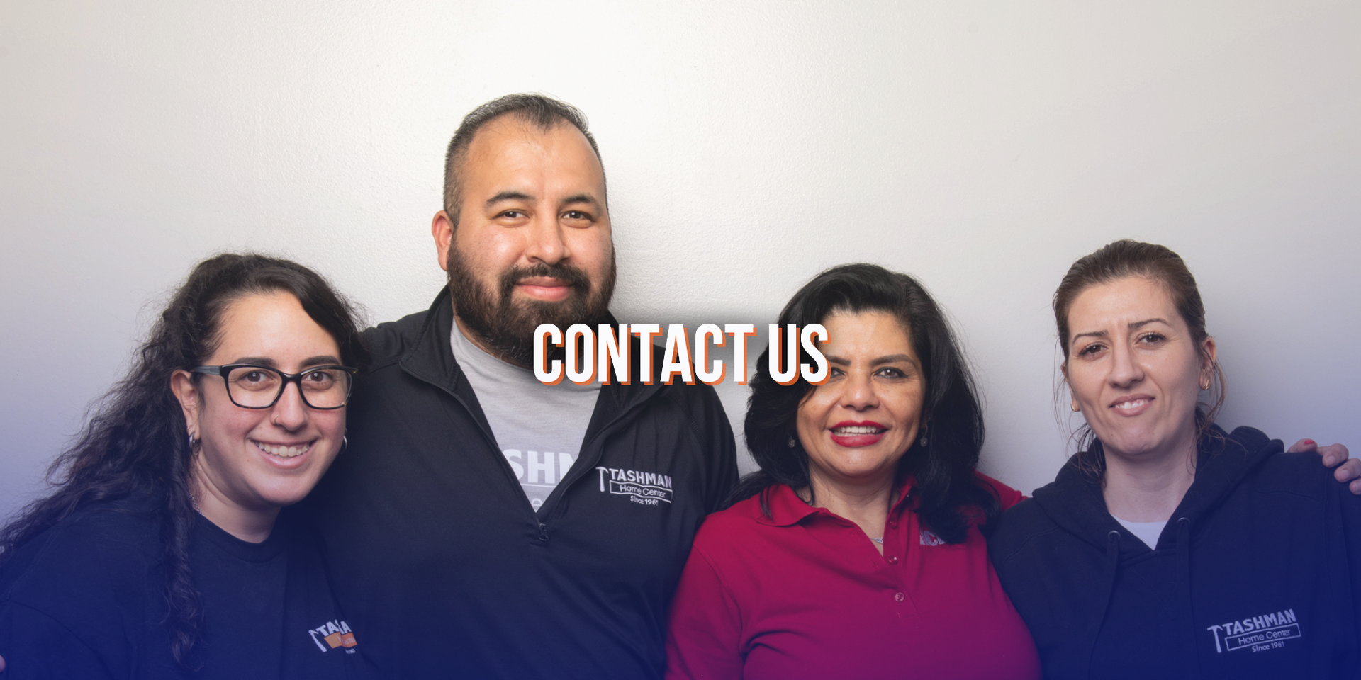 Four people smiling, grouped together indoors; the words