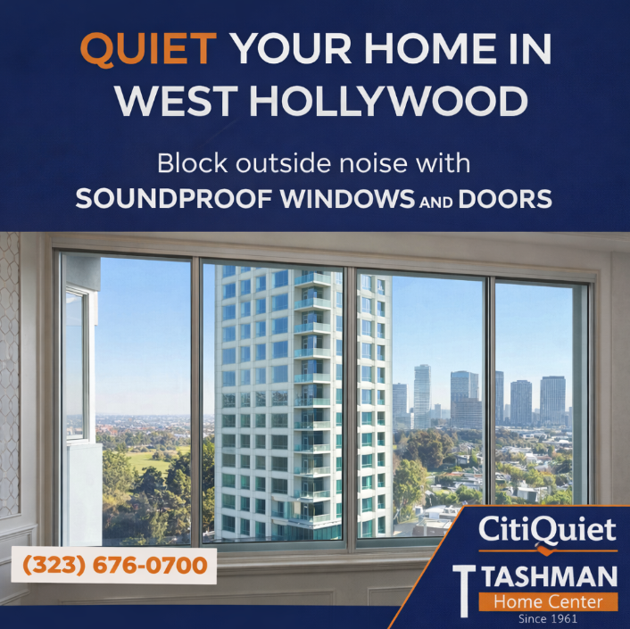 A view of a high-rise city skyline through a large, multi-paned window in a room with cream-colored paneled walls.