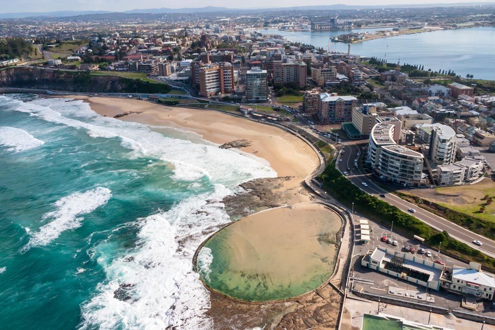 An Aerial View Of A Large Body Of Water Surrounded By Buildings — Prestige Horse Carriages in Newcastle, NSW