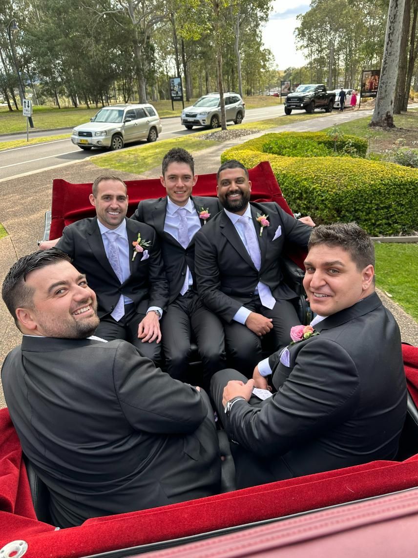A group of men in suits are sitting in a red carriage