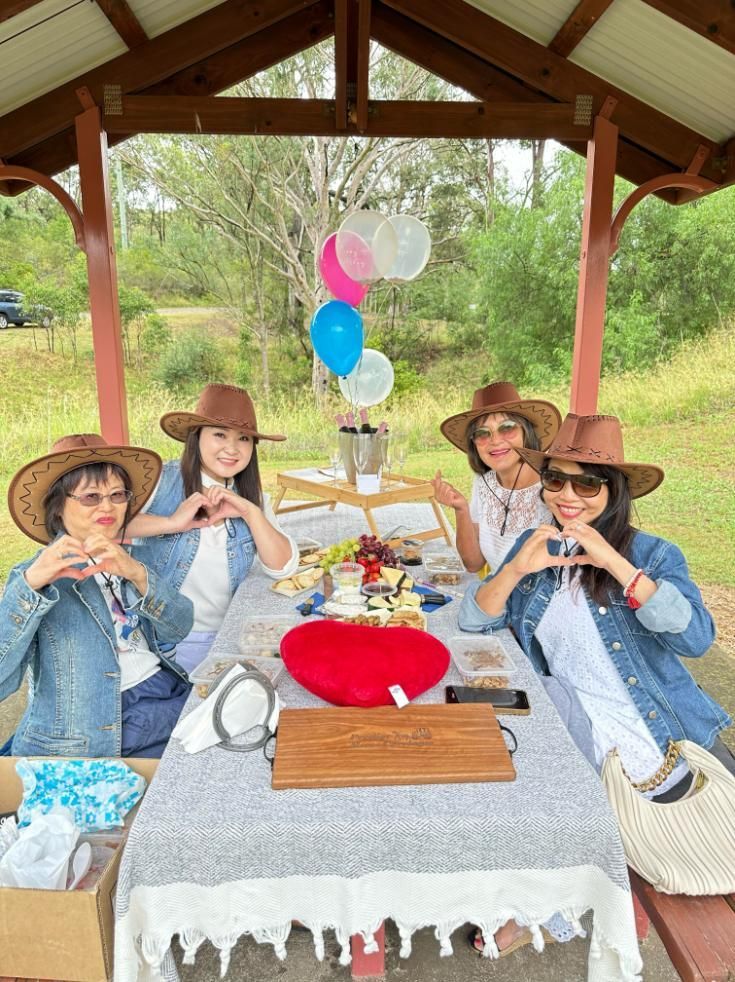 A Group of Women Wearing Cowboy Hats Are Sitting at a Picnic Table — Prestige Horse Carriages in Mitchells Flat, NSW