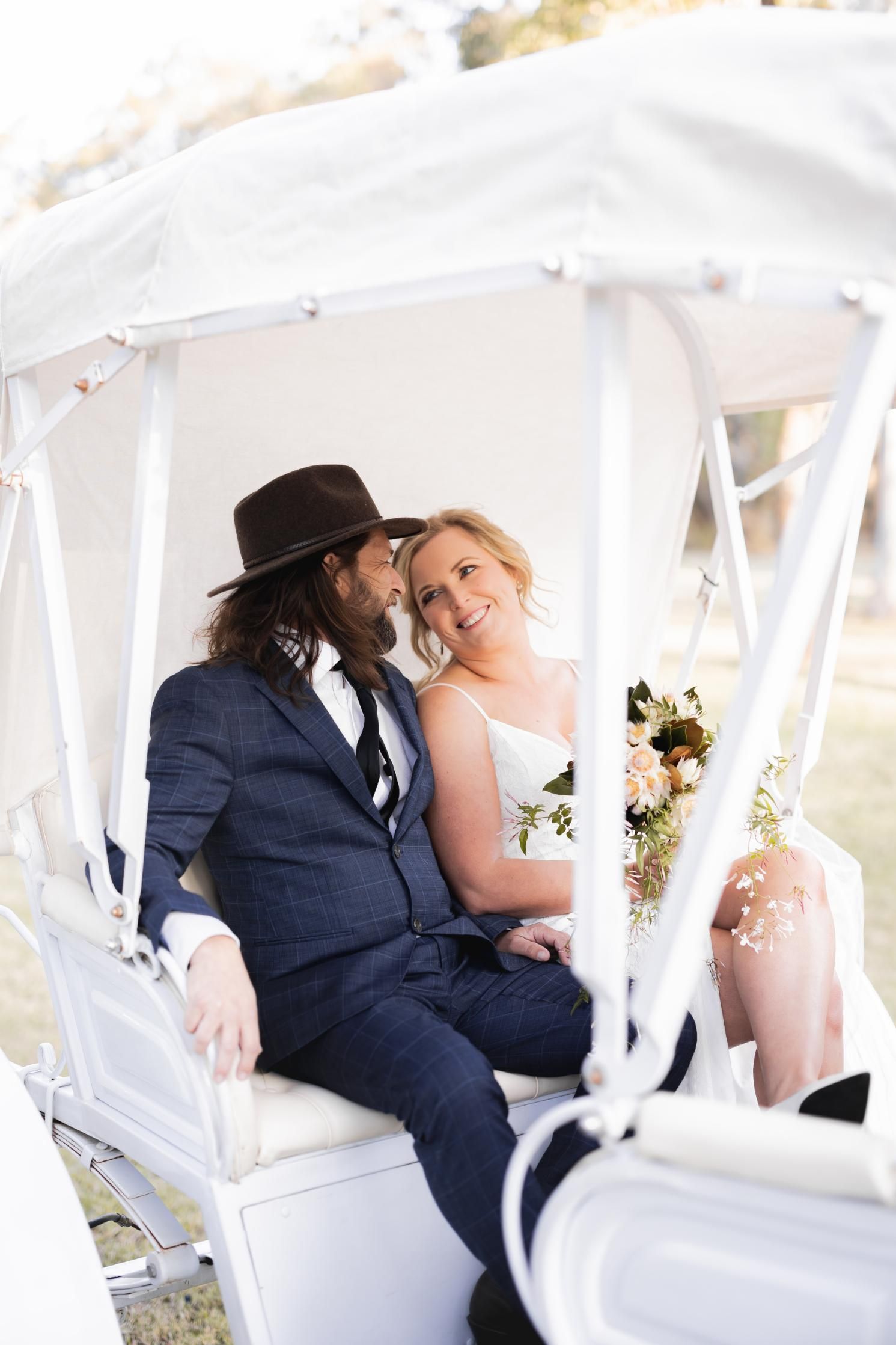 A Bride and Groom Are Sitting in a Horse Drawn Carriage — Prestige Horse Carriages in Mitchells Flat, NSW