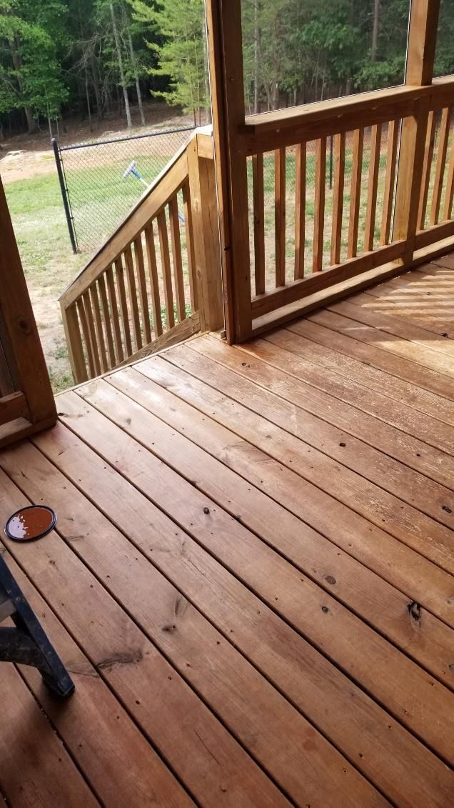 Wooden deck with railing and stairs leading down to a grassy area.