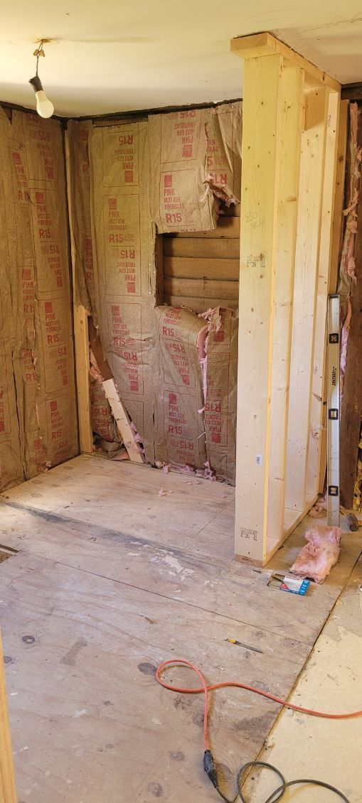 Interior room under construction, walls exposed with insulation.