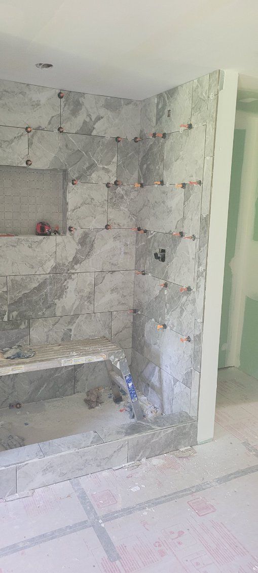 Bathroom under construction with gray stone tiles.