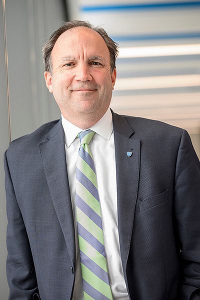 A man in a suit and tie is smiling for the camera.