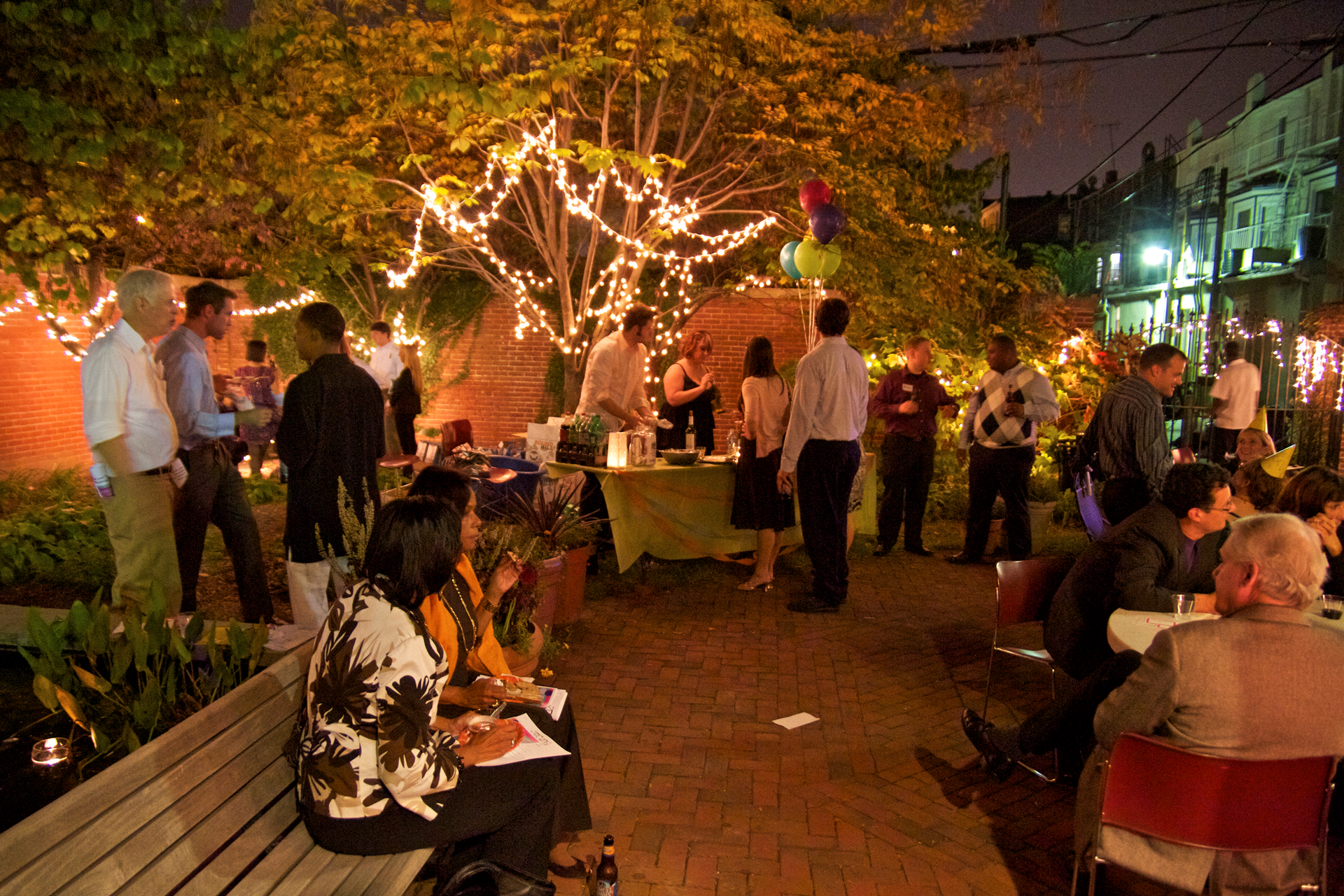 A group of people are gathered in a park at night