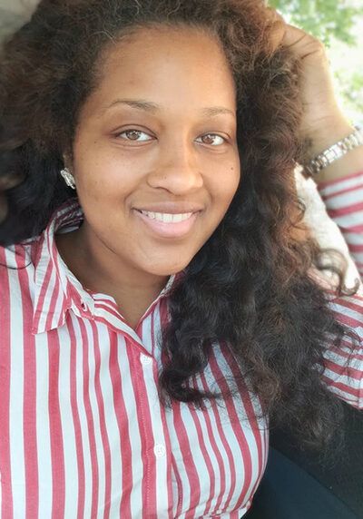 A woman wearing a red and white striped shirt is smiling