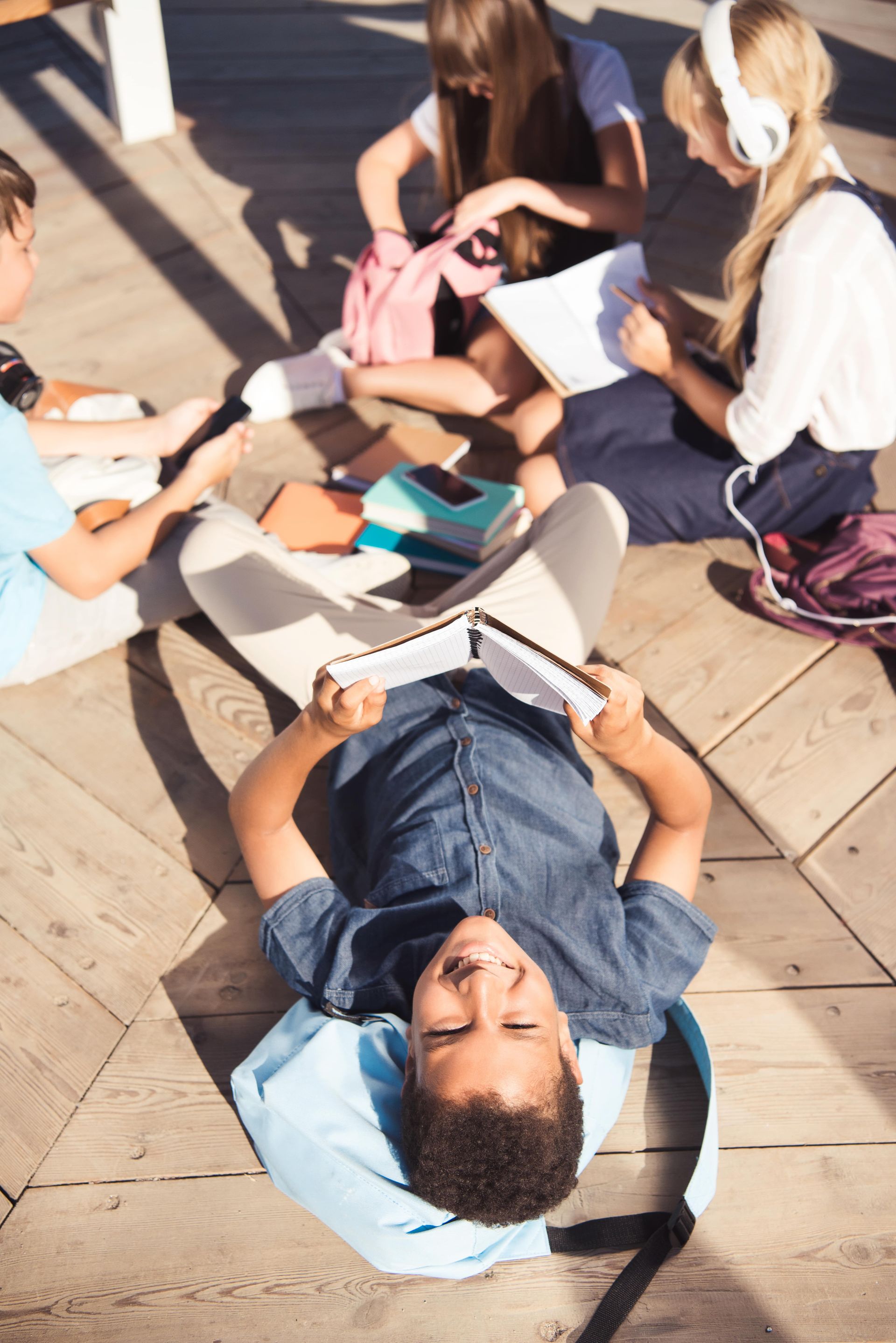 A group of children are sitting on the ground reading books.