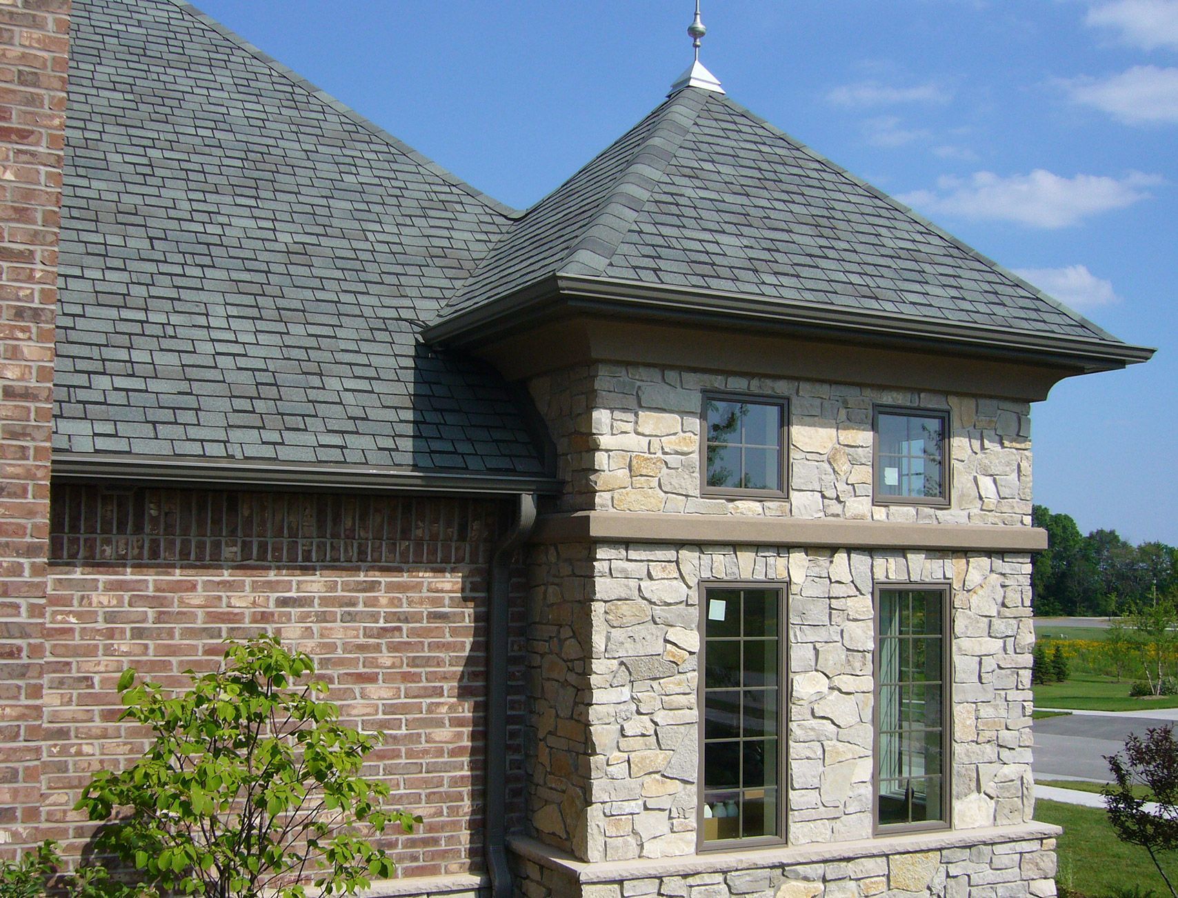 A brick and stone building with a gray roof