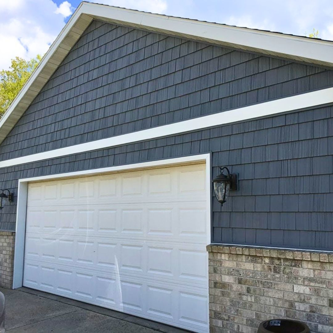 A garage with a white garage door and a brick wall.