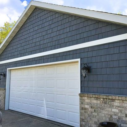A garage with a white garage door and a brick wall.