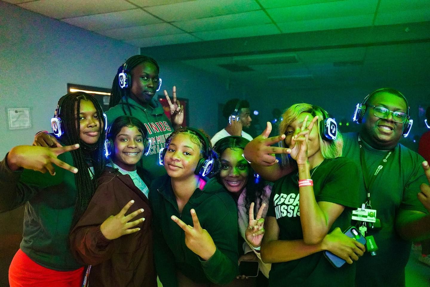 A man and a woman are dancing in a crowd of people wearing headphones.