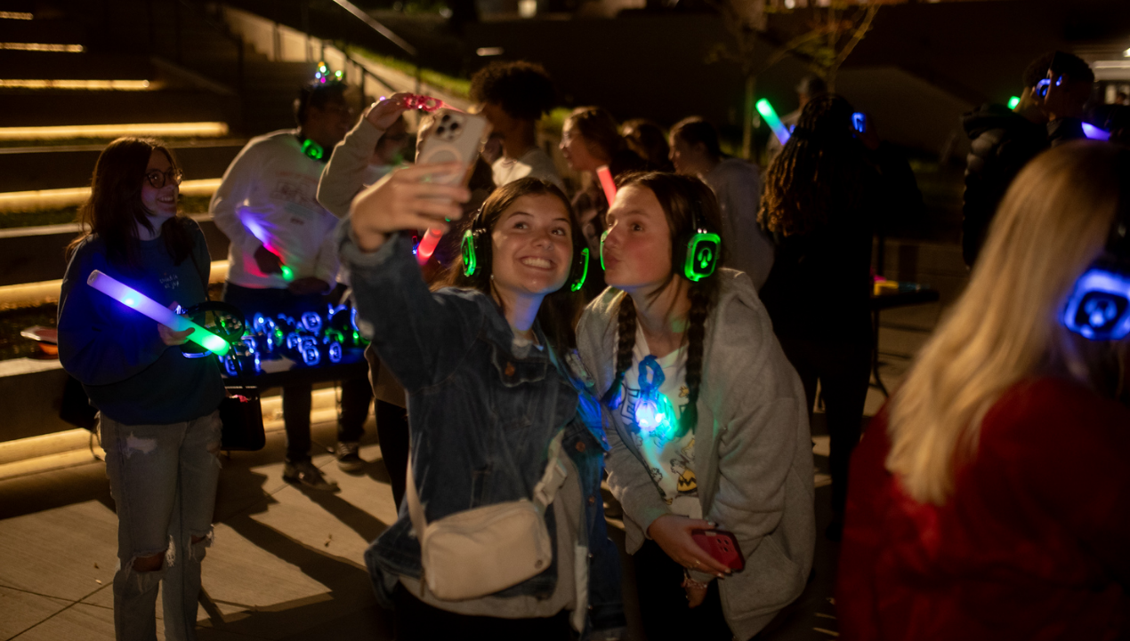 A group of people are dancing in a room with headphones on.