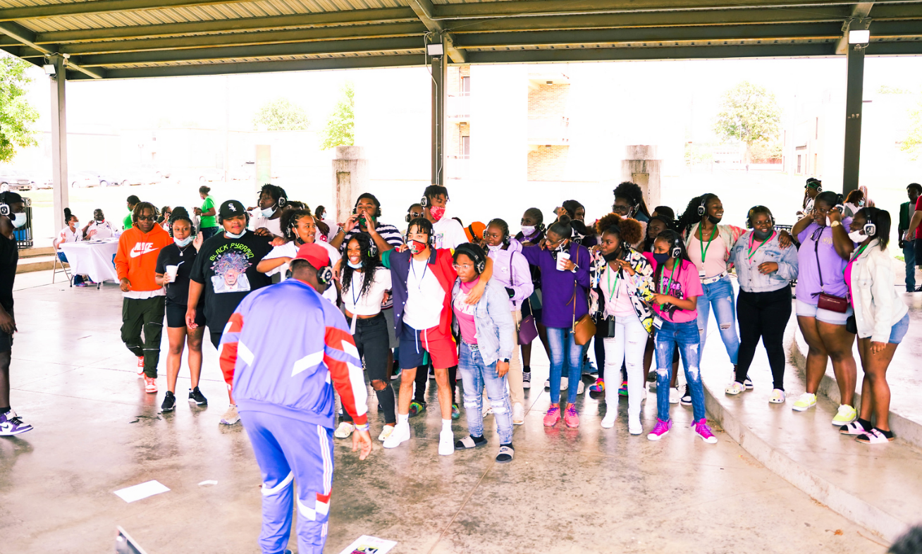 A group of people wearing headphones are sitting on a couch.