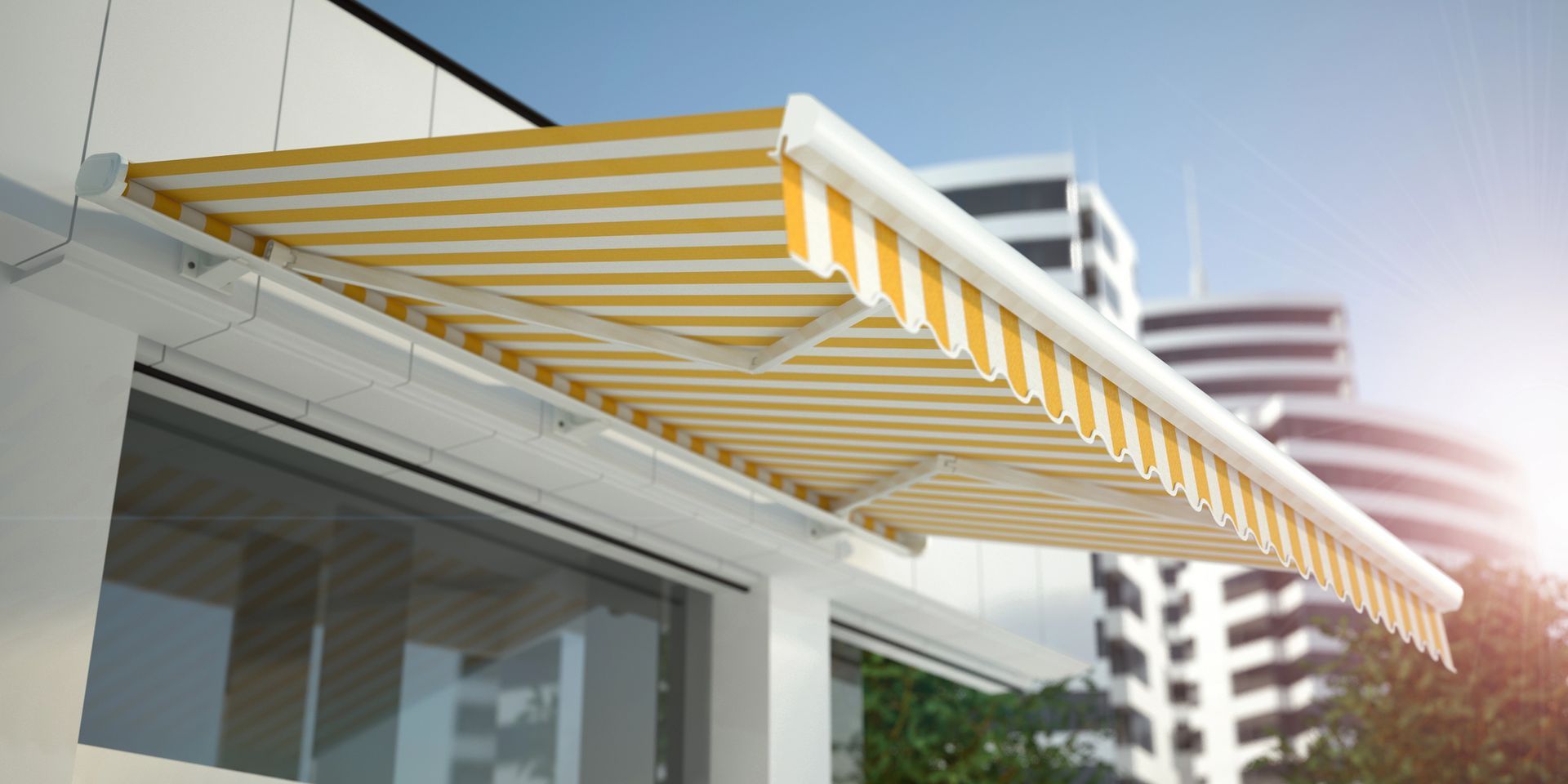 Una tenda da sole retrattile a strisce gialle e bianche si estendeva sopra una grande finestra di un edificio moderno.