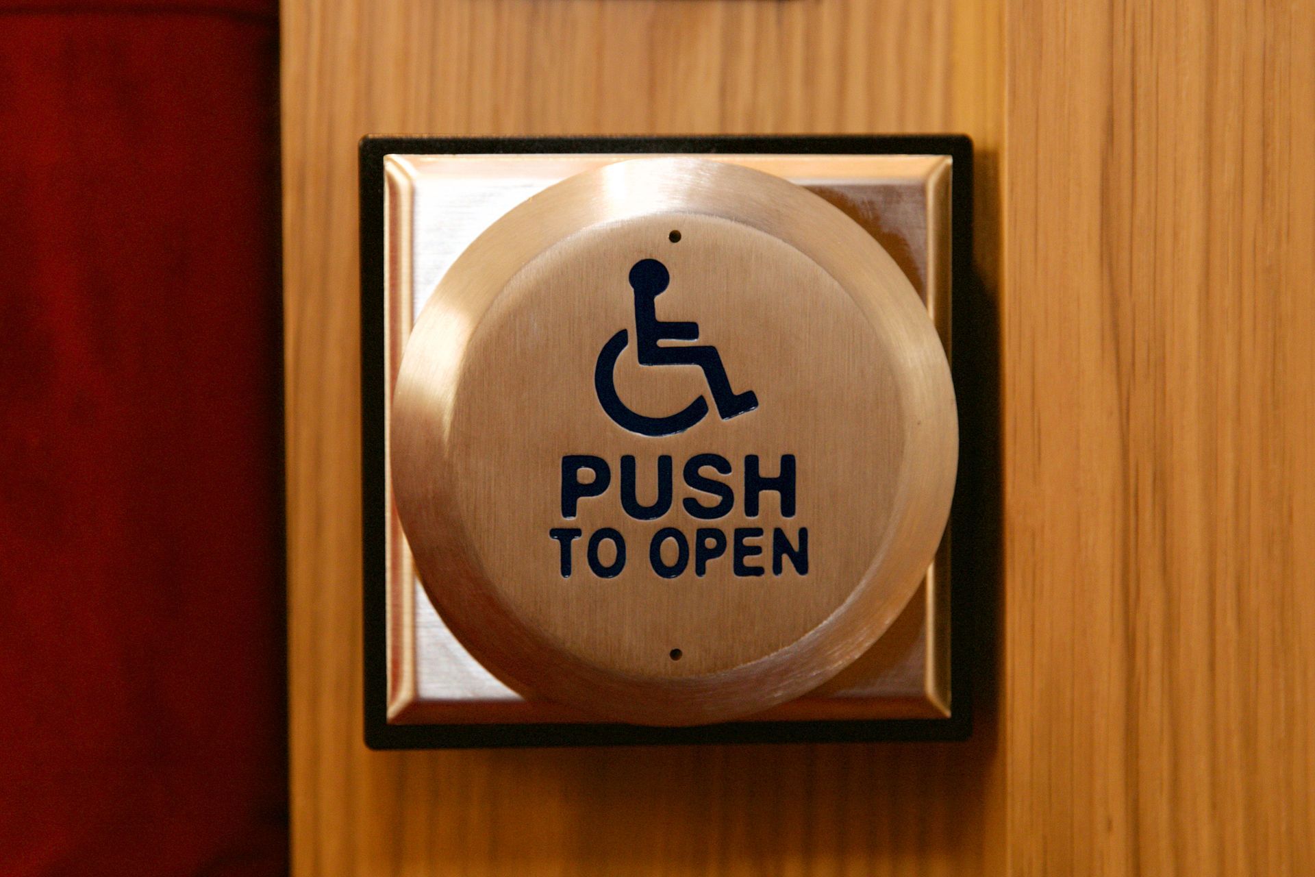 A push to open button with a handicap symbol on it