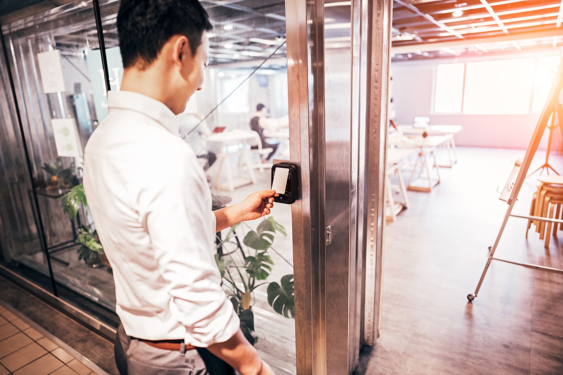 A man is using a smart card to open a door in an office.