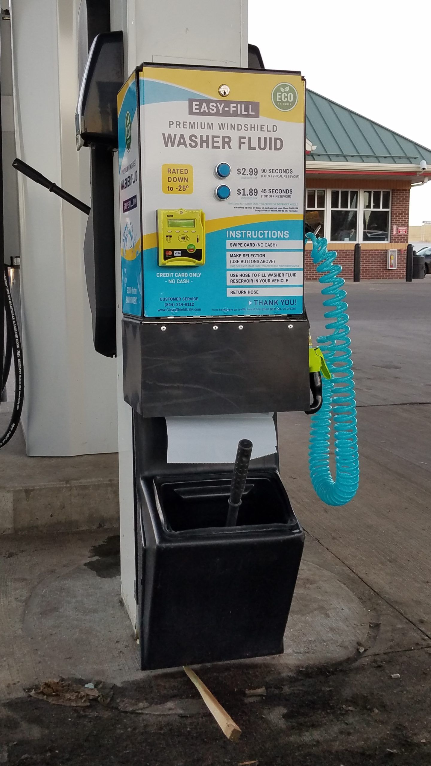 A gas pump with a machine that says washer fluid on it.