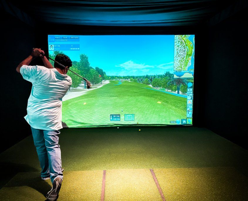Man playing with golf simulator - Canton, MI - The Tailgate Garage