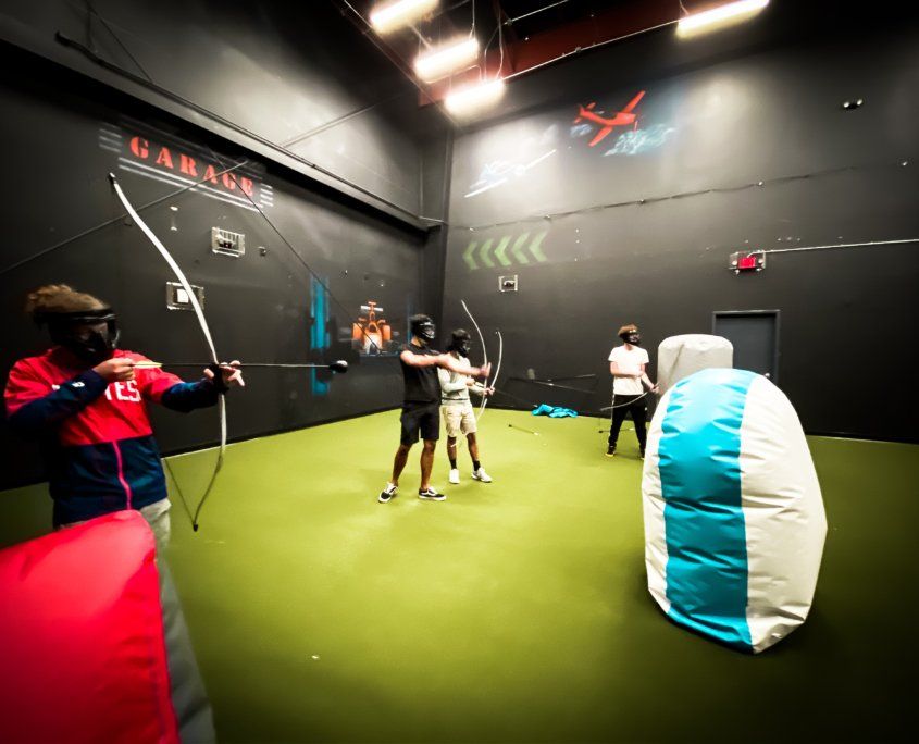 Men holding bows and arrows - Canton, MI - The Tailgate Garage