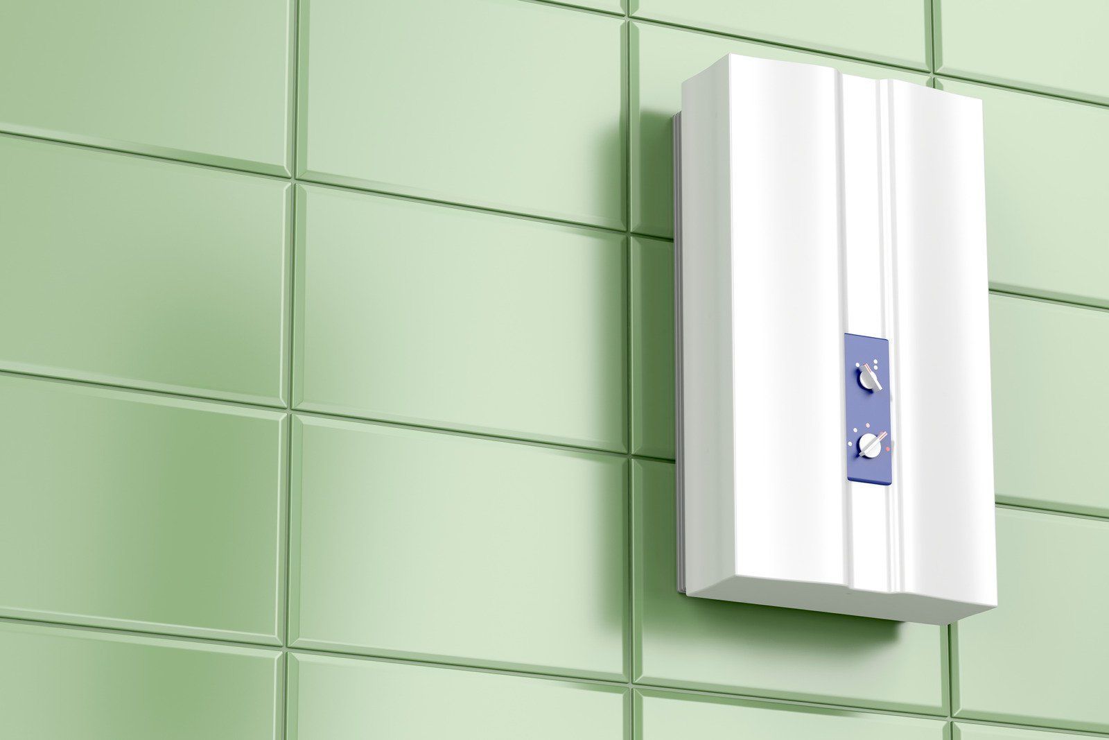 White electric water heater mounted on a green tiled wall. It has two blue control knobs.
