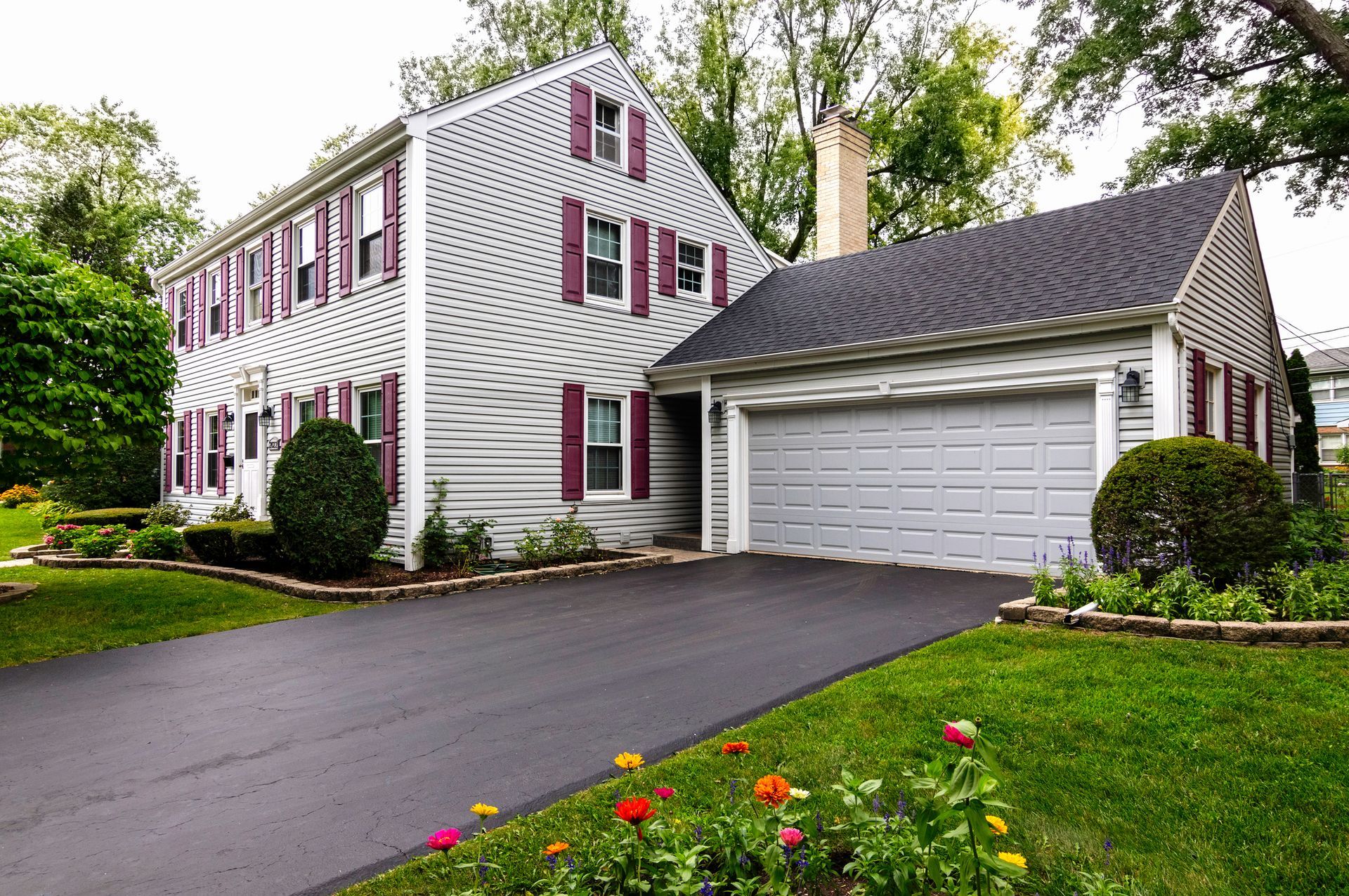 A white house with purple shutters and a garage