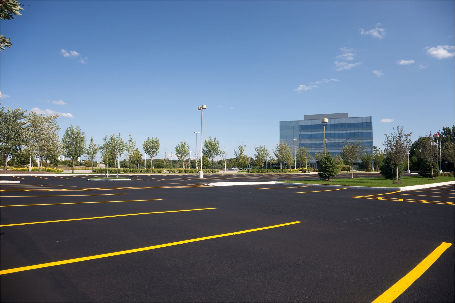 An empty parking lot with a large building in the background