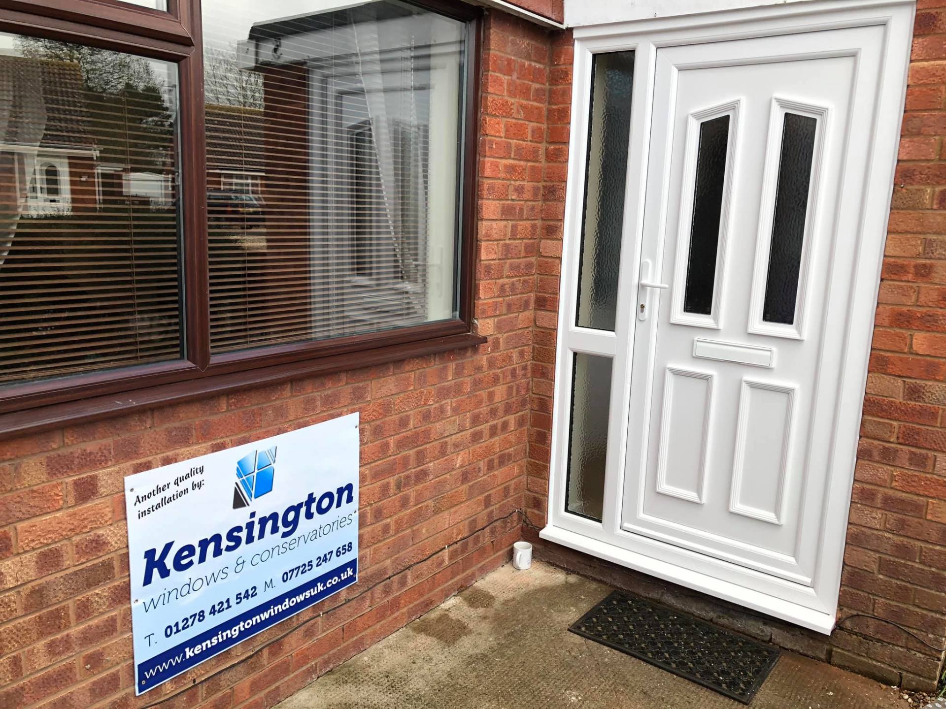 A white door with a sign on the side of it that says kensington.