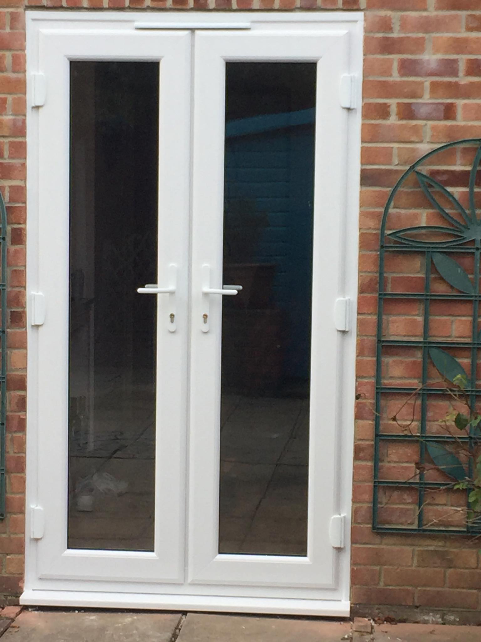 A white door with a brick wall behind it