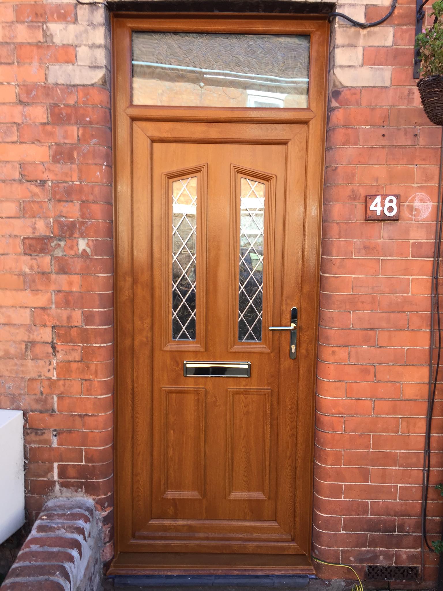 A wooden door is on the side of a brick building.
