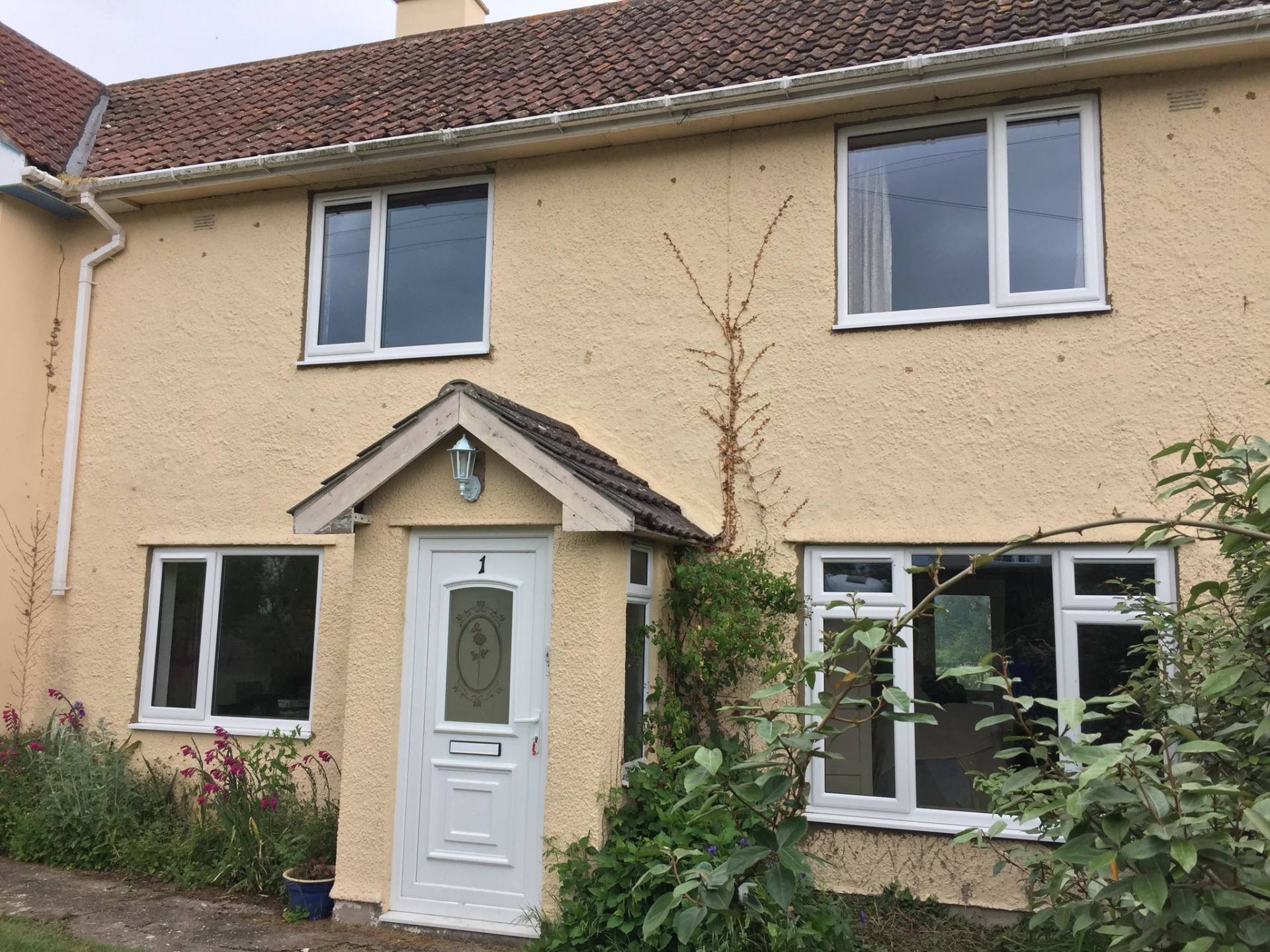 A yellow house with white windows and a white door