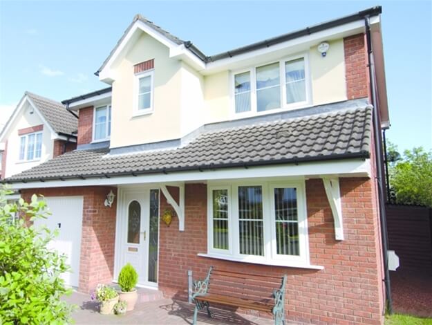 A large brick house with a bench in front of it