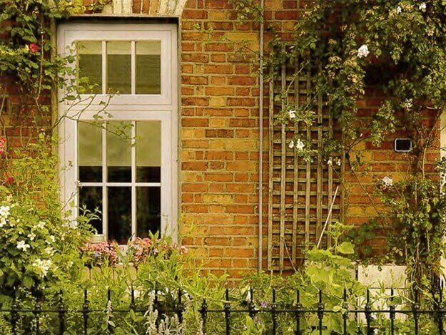 A brick building with a window and a trellis on it