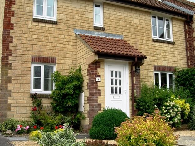 A brick house with a white door and windows