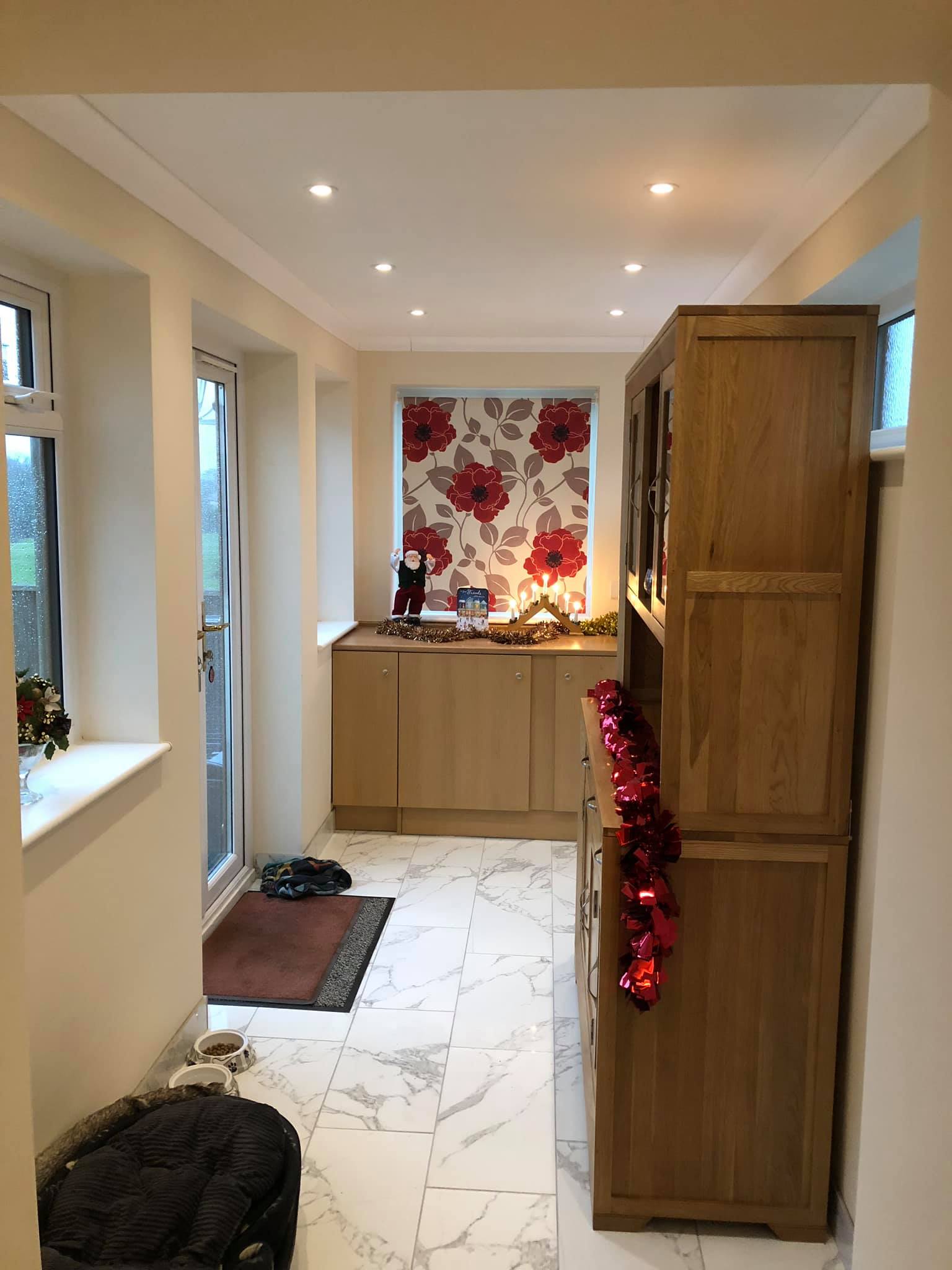 A kitchen with wooden cabinets and a marble floor