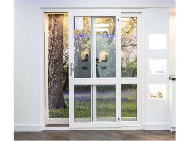 A white sliding glass door with a tree in the background.