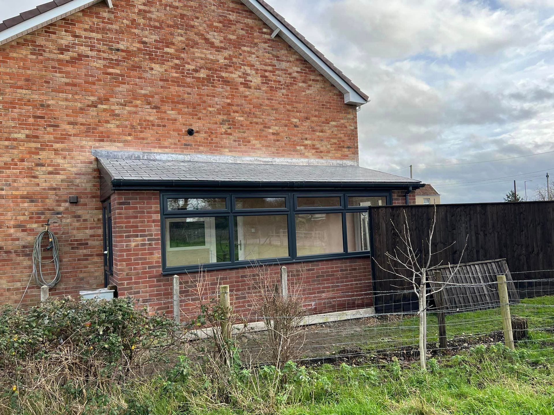 A brick house with a large window in the backyard.
