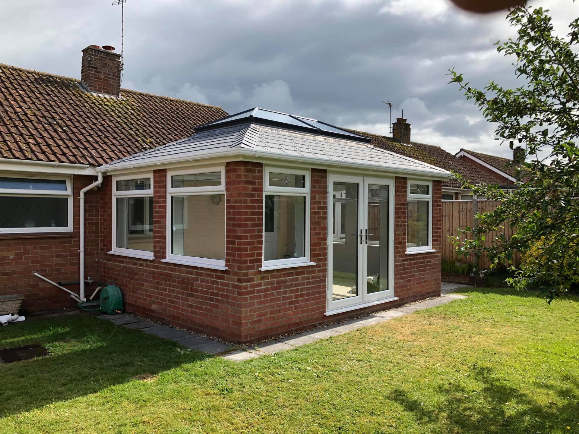 A brick house with a white roof and sliding glass doors.