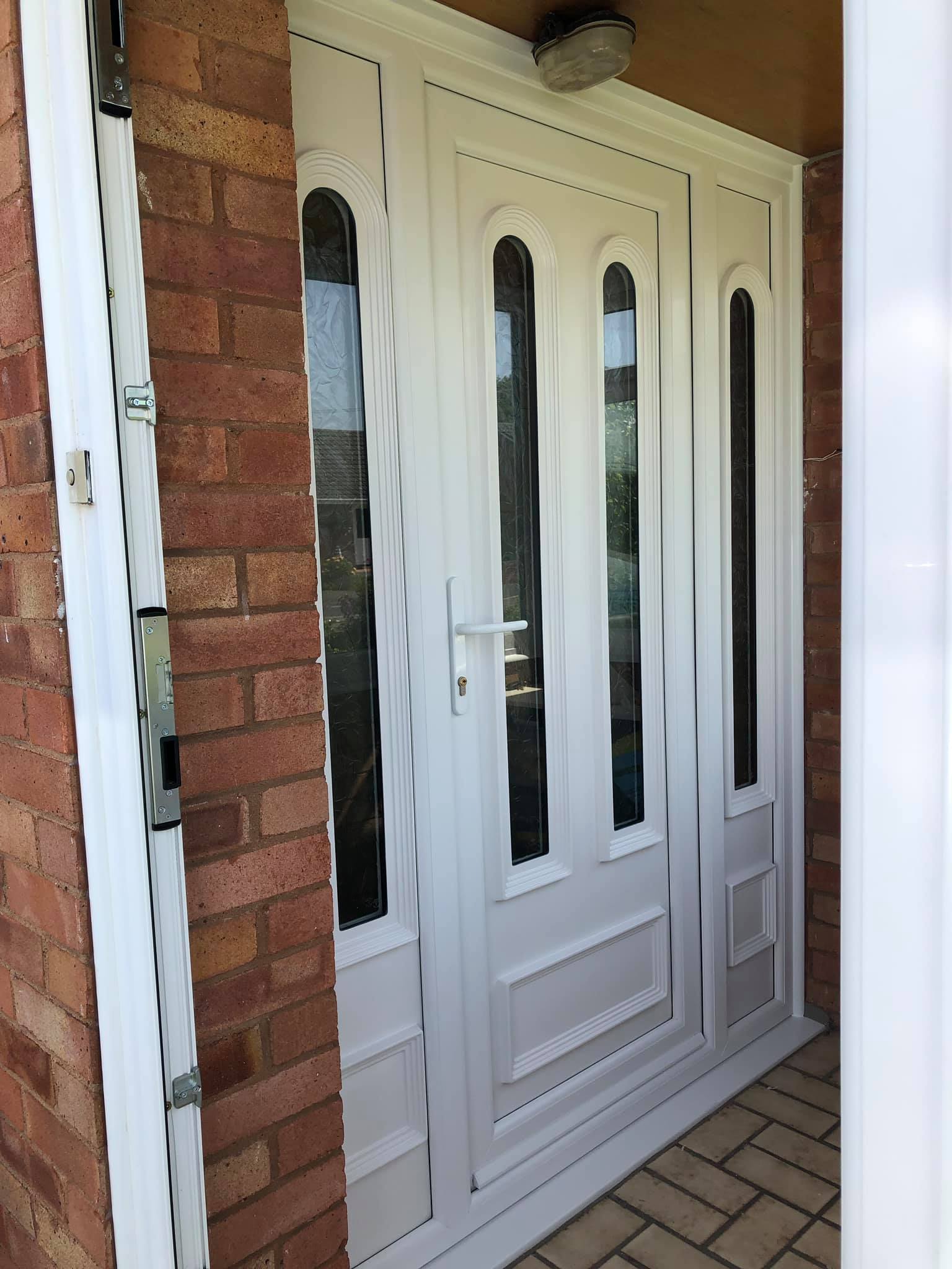 A white door is sitting on a brick wall next to a brick wall.
