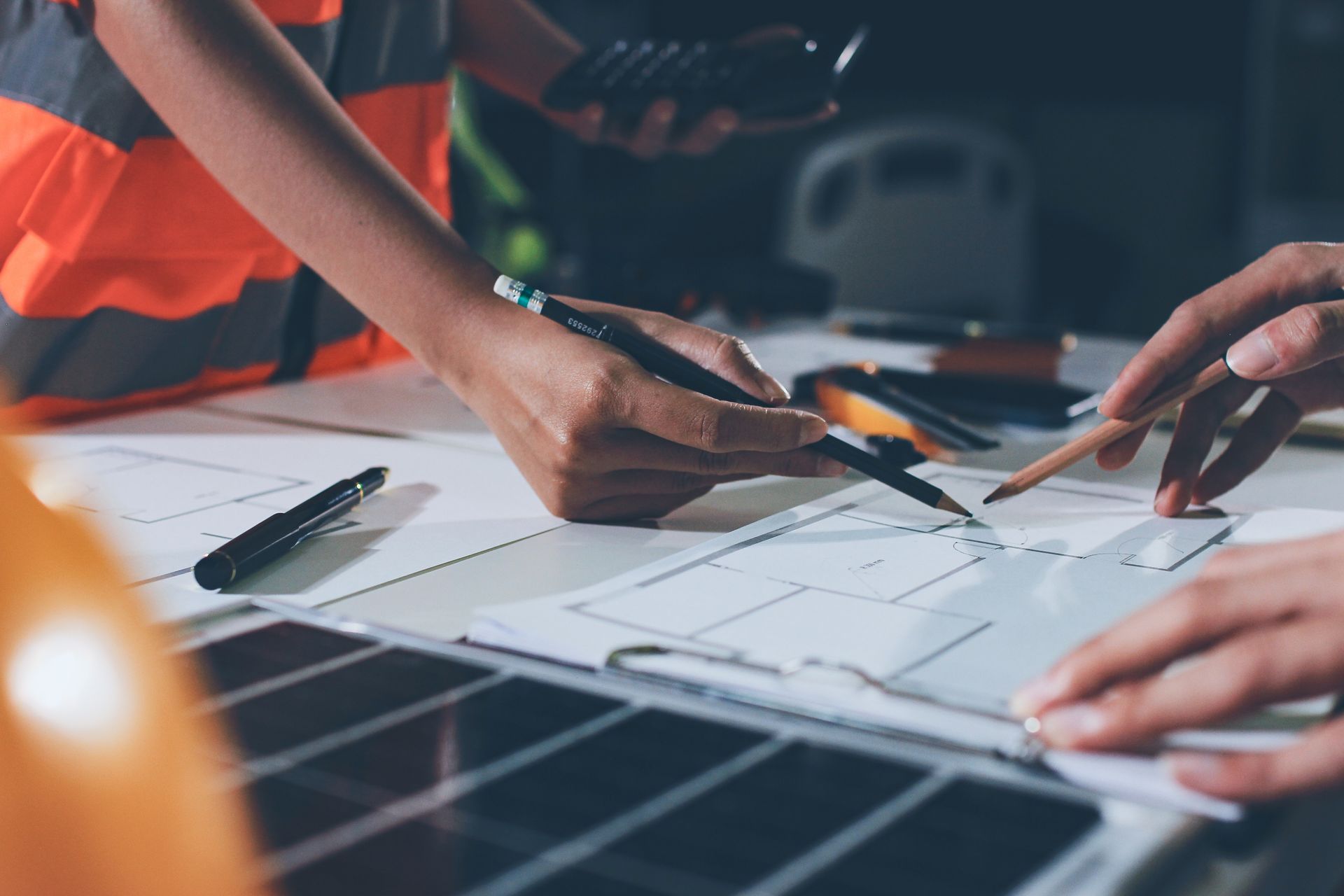 A male and female engineer are working on blueprints for a project.